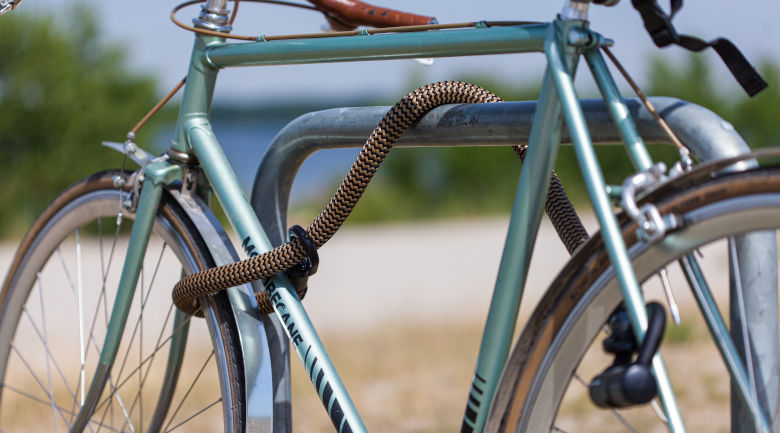 gruenes fahrrad gesichert fahrradstaender langes textil fahrradschloss
